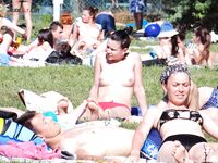 A model enjoying the intense heat of the sun in a relaxed, topless style.