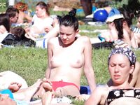 A model enjoying the intense heat of the sun in a relaxed, topless style.