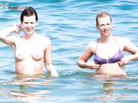 Un rire dans le ressac léger le long d'une plage topless ensoleillée