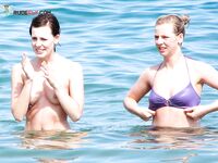 Un rire dans le ressac léger le long d'une plage topless ensoleillée