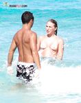 Un rire dans le ressac léger le long d'une plage topless ensoleillée