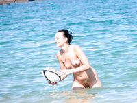 A lady enjoying the coastal breeze in a state of natural, topless relaxation. 3