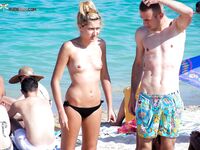 Black Bikini Bottoms and Floral Swim Shorts on Bright Topless Sand