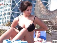Two Women Topless on a City Beach by Apartments