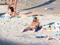 Laag geknield in roze bikinibroekje op warm topless strandzand