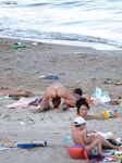Laag geknield in roze bikinibroekje op warm topless strandzand