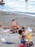 Laag geknield in roze bikinibroekje op warm topless strandzand