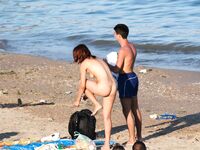 Laag geknield in roze bikinibroekje op warm topless strandzand