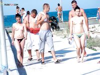 Esce dal mare turchese verso una spiaggia nudista assolata