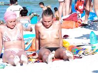 Esce dal mare turchese verso una spiaggia nudista assolata