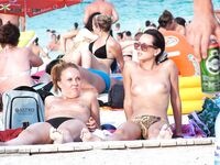 . A model enjoying the intense heat of the sun in a relaxed, topless style. 2
