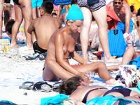 . A model enjoying the intense heat of the sun in a relaxed, topless style. 2