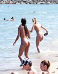 Z klidných vln na sluncem zalitý písek při procházce po nudistické pláži