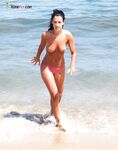 Posing with confidence in a state of total, liberated nudity by the sea. 3