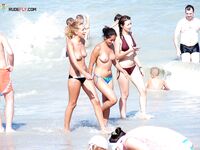 One Woman Topless on the Beach in Black Bikini Bottoms