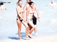 One Woman Topless on the Beach in Black Bikini Bottoms