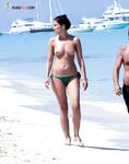 She Walks From the Sea Past a Moored White Yacht