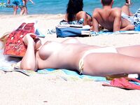 Water Dripping as She Steps From Rocky Nude Beach Shallows
