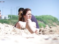 Zvednutá kolena u světlých skal v tiché zátoce nudistické pláže