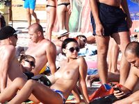 Enjoying the rhythmic sound of the waves while relaxing topless on a private towel. 2
