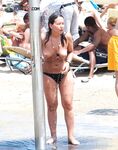 Stepping From the Shallow Surf in White Bikini Bottoms and a Cap
