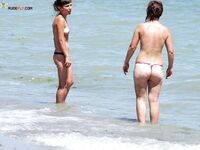 Riendo con bragas negras mientras su amiga se agacha con unas moradas