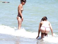 Riendo con bragas negras mientras su amiga se agacha con unas moradas