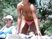 Topless Beach Moment by a Red Railing and Greenery