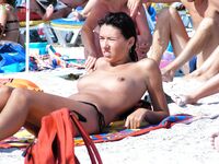 Tarde na areia movimentada de uma praia topless