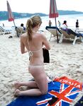 Turquoise Sea and Rocks Frame a Topless Beach Bather