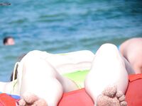 Bas jaune et bronzage topless au soleil sur le sable