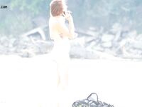 A Rear View Along the Bright Sunlit Nude Beach Shoreline