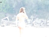 A Rear View Along the Bright Sunlit Nude Beach Shoreline