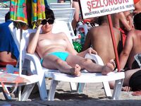 Due donne topless su una spiaggia sabbiosa affollata