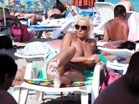 Due donne topless su una spiaggia sabbiosa affollata