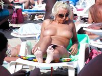 Due donne topless su una spiaggia sabbiosa affollata
