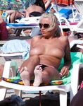 Due donne topless su una spiaggia sabbiosa affollata