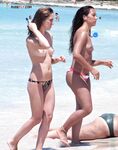 Topless su un telo con un pallone da calcio sulla sabbia