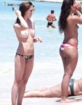 Topless su un telo con un pallone da calcio sulla sabbia