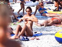 Striped Towel Across Her Lap on a Wooden Beach Lounger