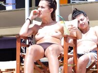 Striped Towel Across Her Lap on a Wooden Beach Lounger