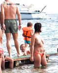 にぎわうトップレスビーチの浅瀬から、赤いタイサイドで上がる