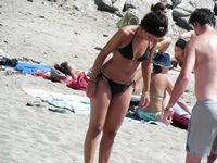 Su flor roja y una sonrisa natural en un paseo por playa topless