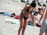 Su flor roja y una sonrisa natural en un paseo por playa topless
