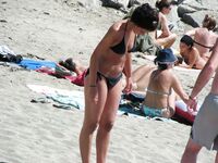 Su flor roja y una sonrisa natural en un paseo por playa topless