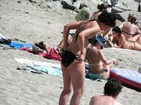 Su flor roja y una sonrisa natural en un paseo por playa topless