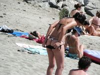 Su flor roja y una sonrisa natural en un paseo por playa topless