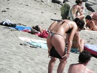 Su flor roja y una sonrisa natural en un paseo por playa topless