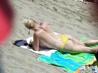 Su flor roja y una sonrisa natural en un paseo por playa topless