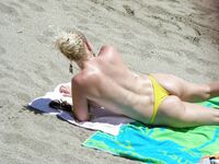 Su flor roja y una sonrisa natural en un paseo por playa topless